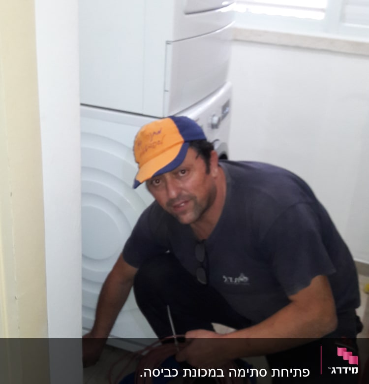 אדם מחזיק כבל ליד מכונת כביסה